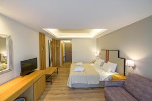 une chambre d'hôtel avec un lit et un canapé dans l'établissement Hotel Europa Olympia, à Olympie