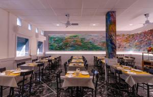 a dining room with tables and chairs and a large painting at Hotel Villa Argentina in Riomaggiore