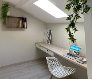 a room with a desk with a laptop and a chair at Appt Ambiance Exotique 2 ch Piscine lagon in Tarbes