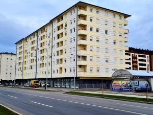 a large white building on the side of a street at Apartman Mirabell, Doboj in Doboj