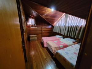 um quarto com 2 camas numa casa de madeira em Hotel Fazenda Boutique Terra do Gelo em Bom Jardim da Serra