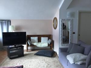 - un salon avec un canapé et une télévision dans l'établissement Appartamento Ottoz Aosta, à Aoste