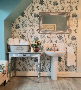 La salle de bains est pourvue d'un lavabo et d'un miroir. dans l'établissement Argyle Guest House, à Tomintoul