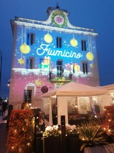 een gebouw met een verlicht bord erop bij Mamita villa in Fiumicino