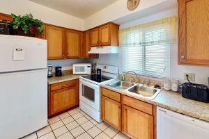 a kitchen with a white refrigerator and a sink at Atlantico 32 in Daytona Beach