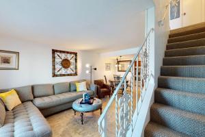 a living room with a couch and a staircase at Atlantico 32 in Daytona Beach