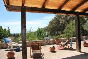 a patio with rocking chairs and a wooden pergola at VILLA CYCAS relax tra mare e natura in Sperlonga