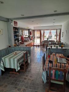 a restaurant with a table and chairs and a room with tables at Posada de la Villa in Villa Gesell