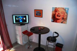 a room with a table and a television and a stool at Pied à Terre en Ville in Marseille