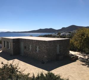 a brick building next to a body of water at The Antiparos Stone House in Antiparos