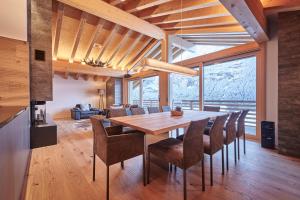 a kitchen and dining room with a wooden table and chairs at Attico Grindelwald in Grindelwald