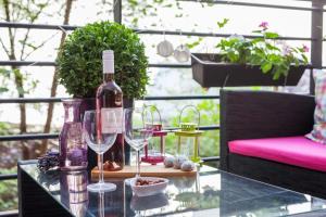 einen Glastisch mit einer Flasche Wein und zwei Gläsern in der Unterkunft Best Downtown Apartman in Budapest