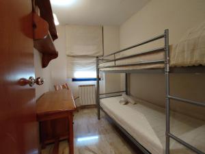 a room with two bunk beds and a desk at Calafell Sant Antoni in Calafell