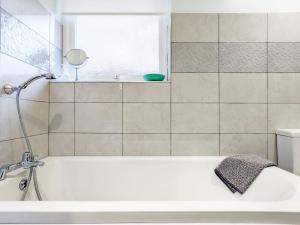 a white bath tub in a bathroom with a window at Ems Cottage - Emsworth in Emsworth +14 photos