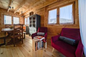 a living room with a red couch and a table at Chalet L'Abitiz in Puyvalador