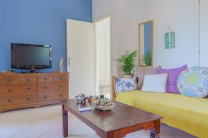 un soggiorno con divano giallo e TV di Loggos Sweet Home a Lixouri