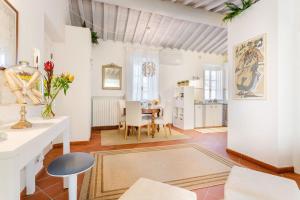 een keuken en een woonkamer met een tafel en stoelen bij Casa Santa Zita, A Toproof Penthouse Apartment with Elevator and Private Garden Inside the Walls in Lucca