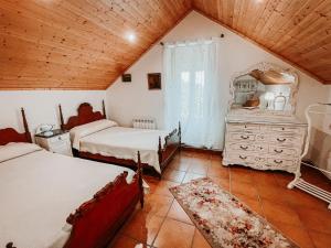 a bedroom with two beds and a wooden ceiling at Pazo Dos Remedios in Ponteareas