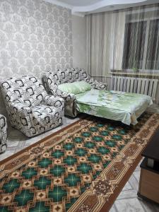 uma sala de estar com um sofá e uma cama em Квартира в районе жд вокзала em Shchuchinsk