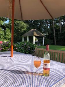 uma garrafa de vinho sentada numa mesa com um copo em Schilde Cottage em Schilde