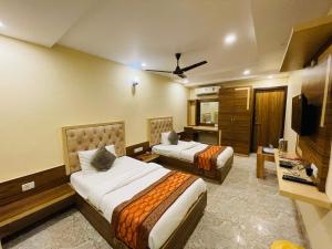 a hotel room with two beds and a television at HOTEL AUGUSTO in Varanasi