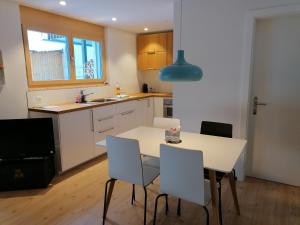 a kitchen with a white table and chairs at CANOLS#32 in Valbella