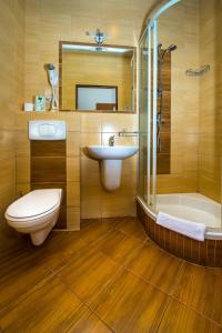 a bathroom with a sink and a toilet and a tub at Hotel Nad Pisą in Pisz