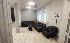 a living room with two black leather couches at MISLENY HOME in Kozármisleny