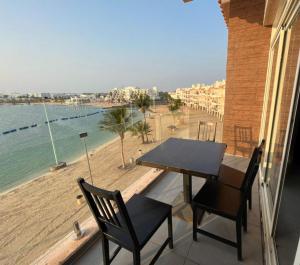a table and chairs on a balcony with a view of the beach at درة العروس فان بيتش الخاصه in Durat  Alarous