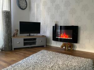 a living room with a tv and a fireplace at Bournemouth Luxury Hot Tub 1 Bed Garden Flat in Bournemouth