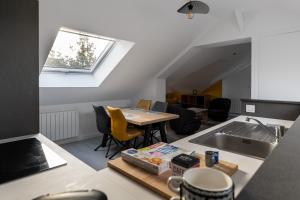 a kitchen and living room with a table and a sink at Pomme de Pin in Frehel