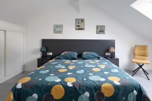 um quarto com uma cama e uma cadeira em Pomme de Pin em Frehel