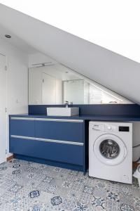 ein Badezimmer mit einer Waschmaschine und einem Spiegel in der Unterkunft Pomme de Pin in Frehel