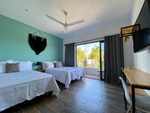 a bedroom with two beds and a large window at Coba Studios in Cancún
