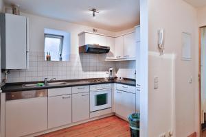 a kitchen with white cabinets and a white refrigerator at Apartments Fleischhauerstraße in Lübeck