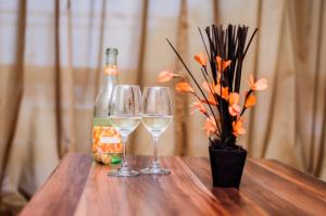 two wine glasses and a bottle on a wooden table at Cantilena Complex in Sunny Beach