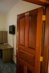 una porta in legno con un cartello sopra in una stanza di Turbine Ngong Hotel a Ngong