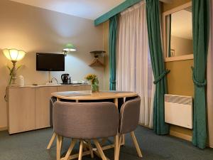 Cette chambre dispose d'une table, de chaises et d'une télévision. dans l'établissement Hotel De La Tour, à Pont-de-lʼArche