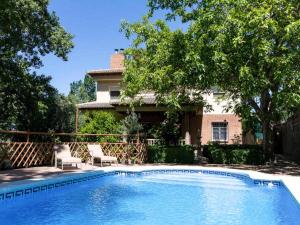 una piscina con 2 sillas y una casa en Casa rosa del romeral, en Nigüelas