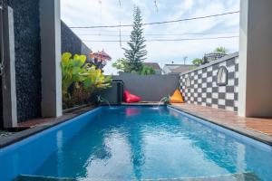 a swimming pool in the backyard of a house at Josh Guest House in Singaraja