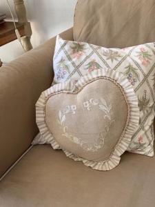 a heart shaped pillow sitting on a couch at Villa Soraya , quiet location with big garden near beach and old town of NICE in Nice