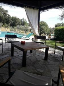 a wooden table sitting on a patio next to a pool at Casolare il Moro in Monte San Savino