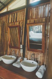 a bathroom with two sinks and a mirror at La Bambouseraie in Balgue
