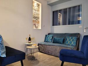 a living room with two blue chairs and a couch at L établissement LA PLAGE A 2 PAS vous propose, 3 Appartements DEUX chambres, 1 appartement une pièce avec CLIMATISEUR , Netflix, lits faits à votre arrivée, serviettes de toilette, Ménage, Wifi, en hyper centre ,Plage à 100m, BOX à Vélos in Dieppe
