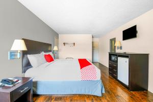 a bedroom with a bed and a desk and a television at OYO Hotel Irving DFW Airport South in Irving