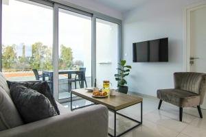 a living room with a couch and a table at Phaedrus Living - Seaside Executive Flat Harbour 101 in Paphos City +8 photos
