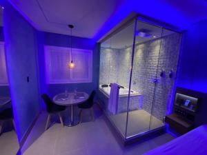łazienka z prysznicem, stołem i krzesłami w obiekcie Fantasy Motel w mieście Salvador
