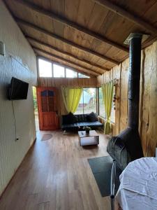 a living room with a couch and a large window at Ruka Huilipan in Nueva Imperial
