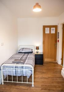 Schlafzimmer mit einem Bett und Holzboden in der Unterkunft The Golden Lion Hotel in Middlewich
