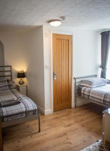 Cette chambre comprend 2 lits et une porte en bois. dans l'établissement The Golden Lion Hotel, à Middlewich